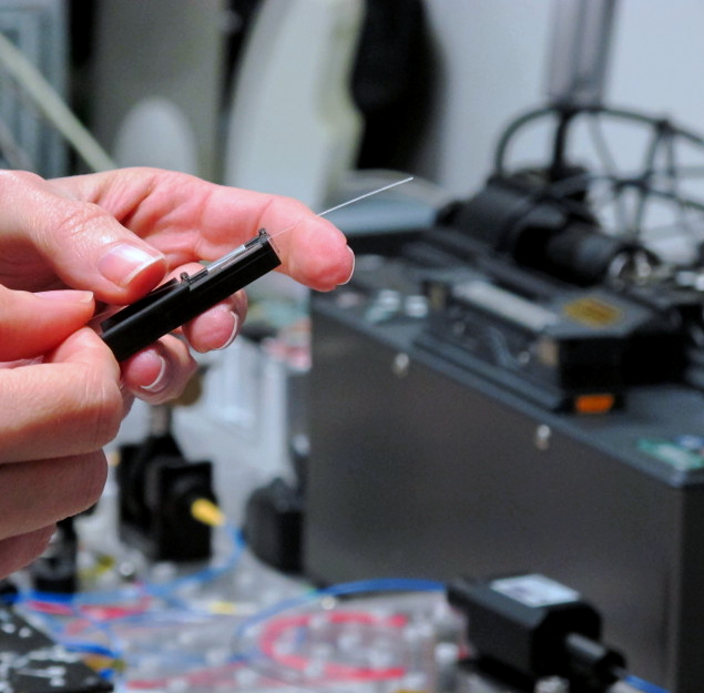 blue optical fiber held in a hand